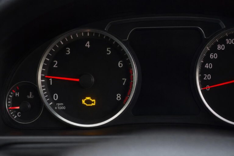 Autó műszerfala világító motorhiba-jelző ikonnal, amely kompresszióhibára is utalhat