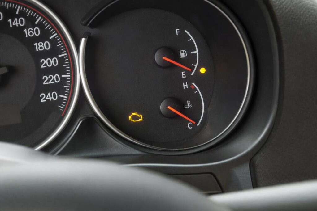 Benzines autó műszerfala világító motorhiba-jelzővel és alacsony üzemanyagszintet mutató üzemanyagszint-jelzővel