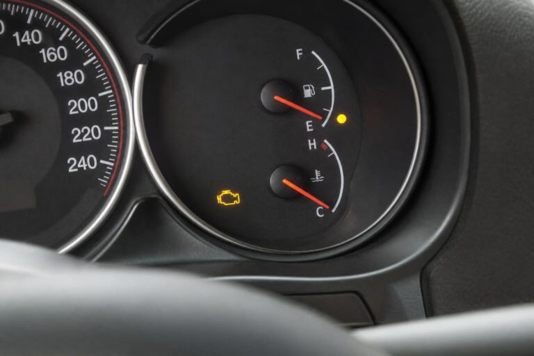 Benzines autó műszerfala világító motorhiba-jelzővel és alacsony üzemanyagszintet mutató üzemanyagszint-jelzővel