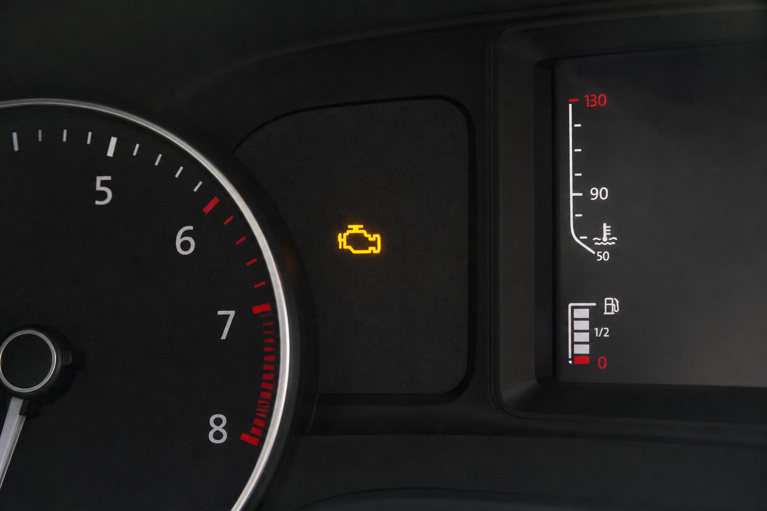 Autó műszerfala világító sárga check engine motorhiba-jelző ikonnal