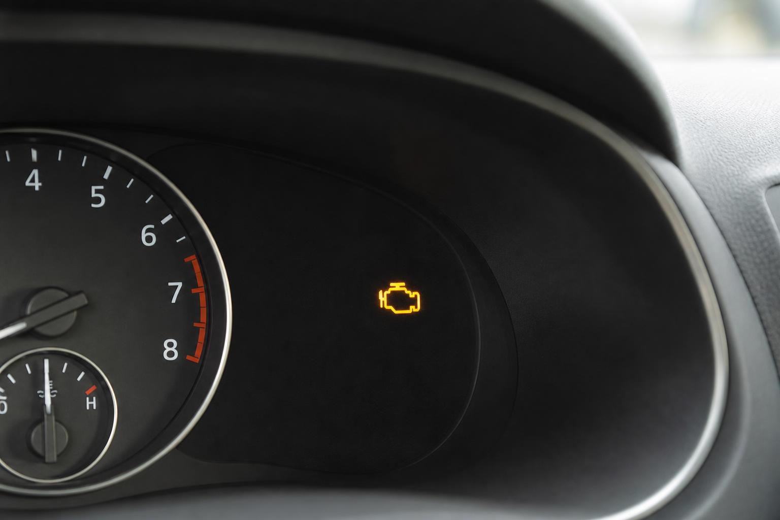 Autó műszerfalának közeli képe világító sárga check engine motorhiba-jelzéssel
