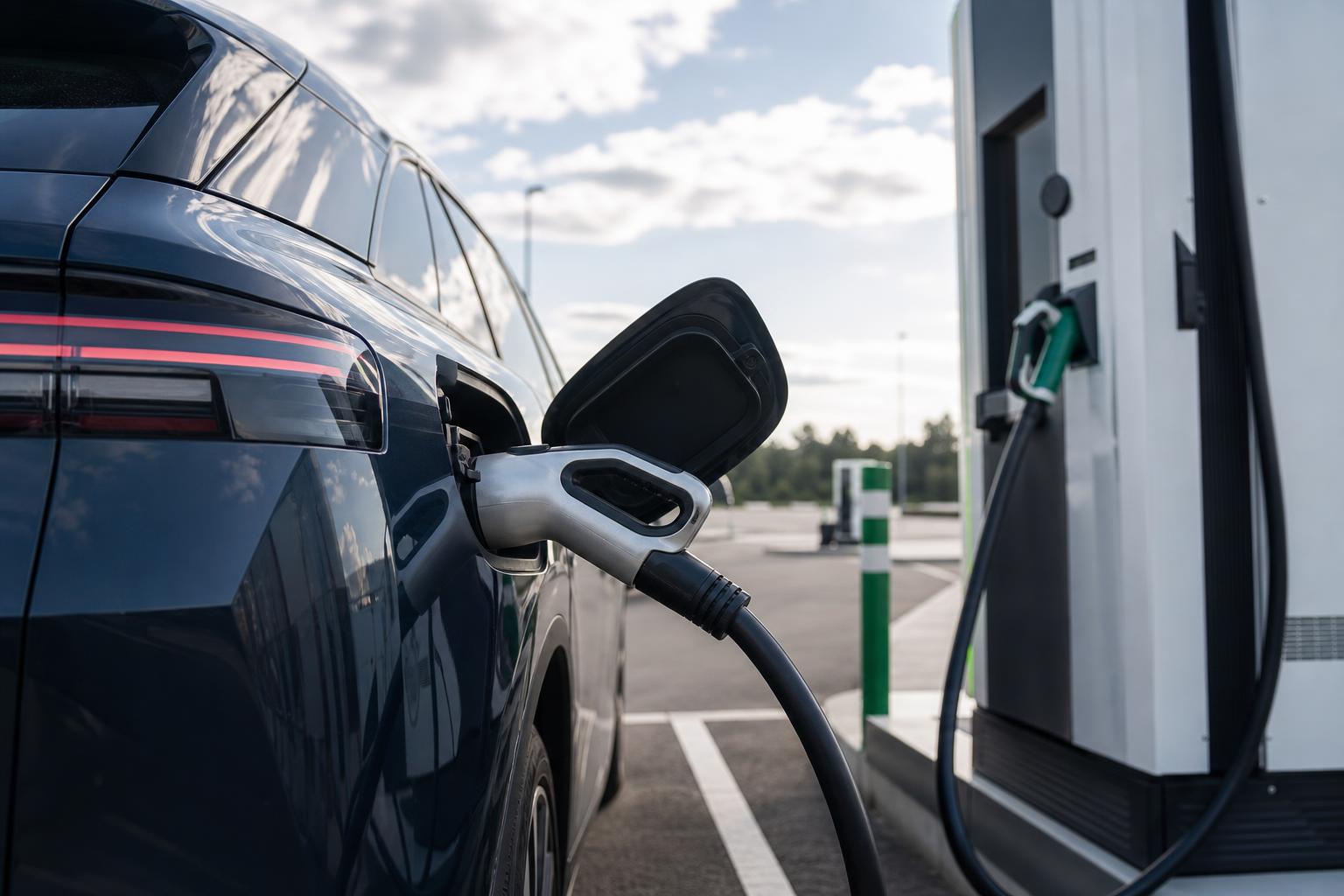 Elektromos autó töltőkábele egy autópálya melletti töltőállomáson