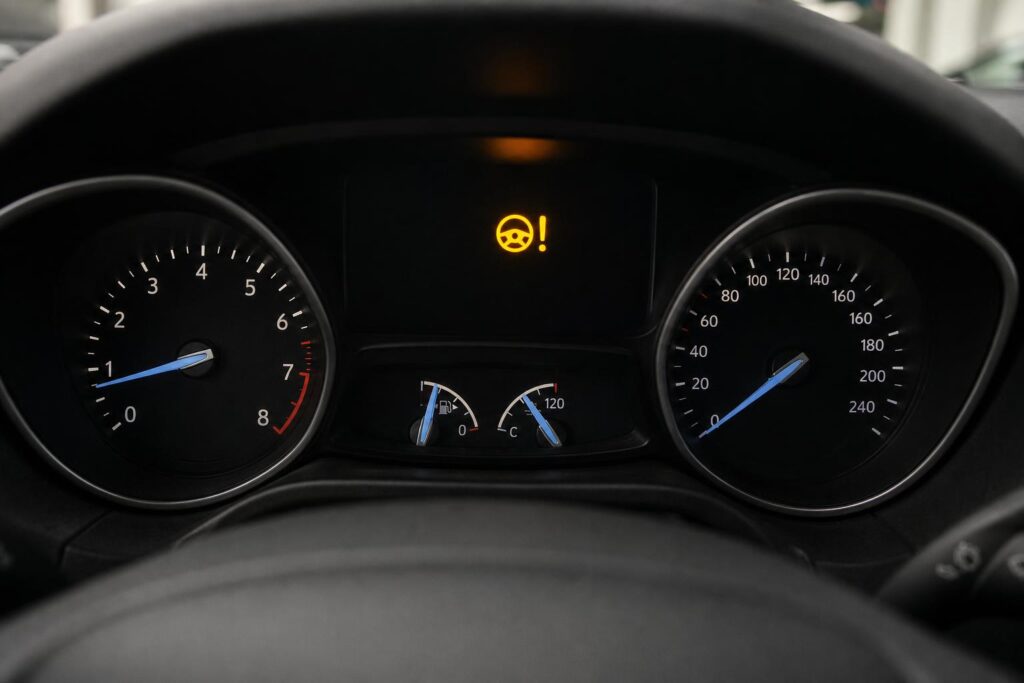 Autó műszerfala elektromos szervokormány-hibát jelző kormánykerék ikonnal