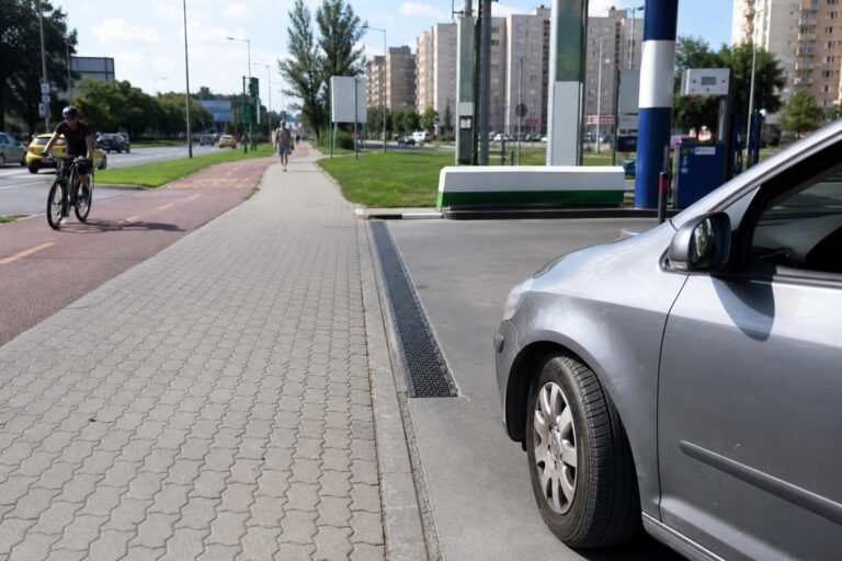 Autó hajt ki benzinkútról a járdát és kerékpárutat keresztező kijáraton