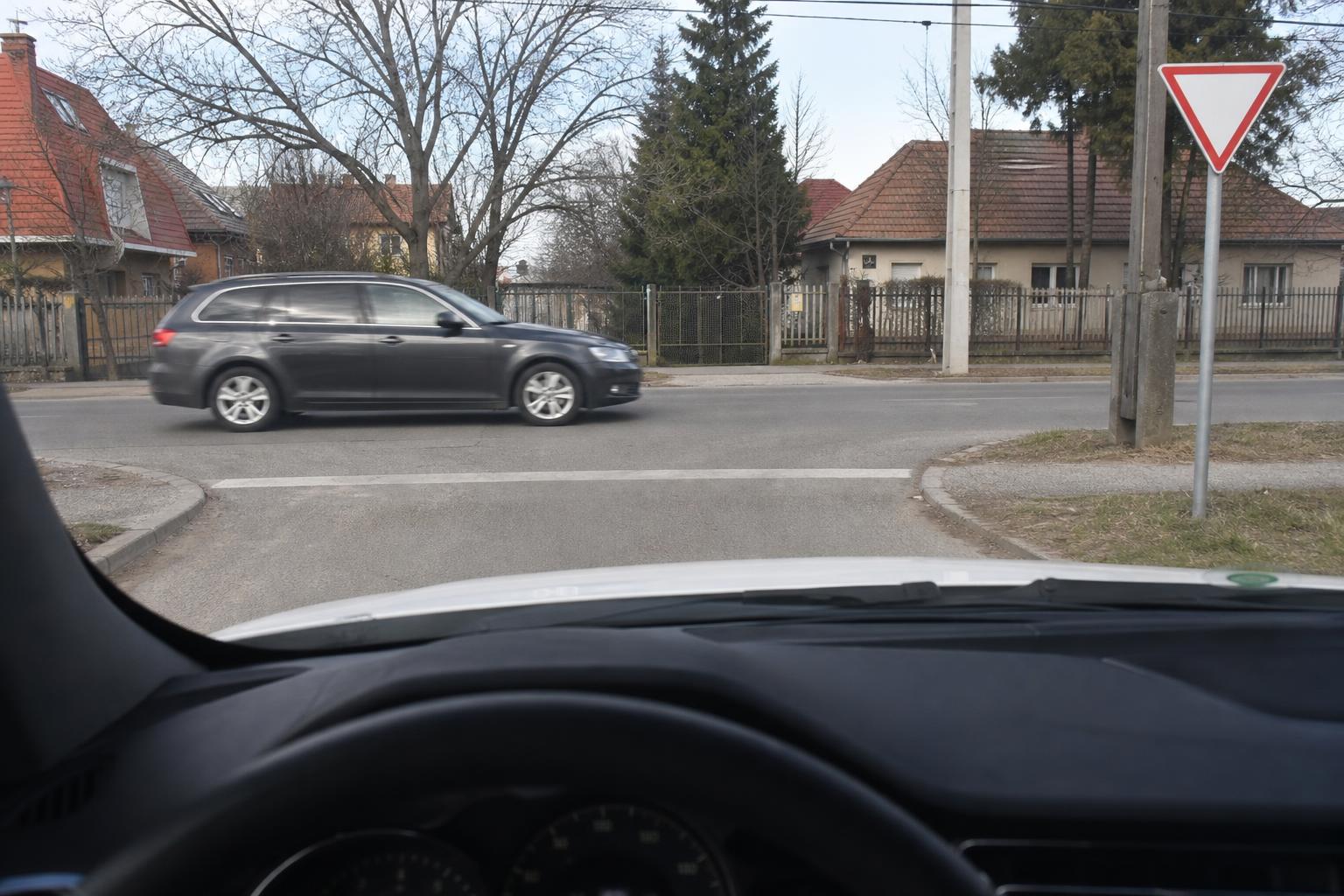 Magyarországi útkereszteződés elsőbbségadás kötelező táblával és a keresztező úton haladó járművel