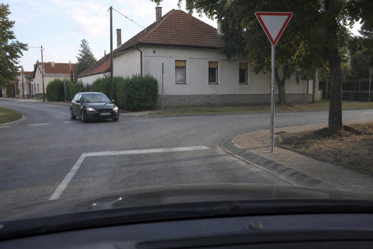 T alakú kereszteződés elsőbbségadás kötelező táblával és oldalról érkező autóval