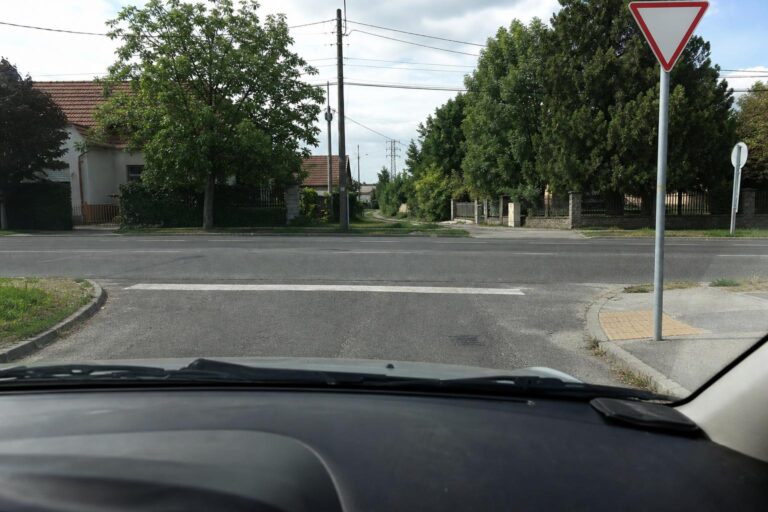 Autóból látható T alakú kereszteződés elsőbbségadás kötelező táblával és stopvonallal