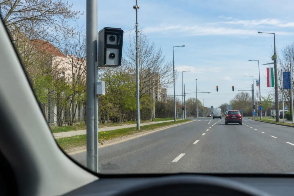 Fix traffipax egy út menti oszlopon, előtte autóút és jól látható forgalmi jelzések