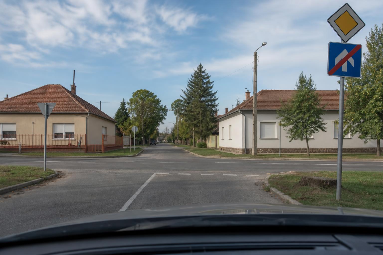 Autóból látható magyar főútvonal vége tábla egy kereszteződés előtt