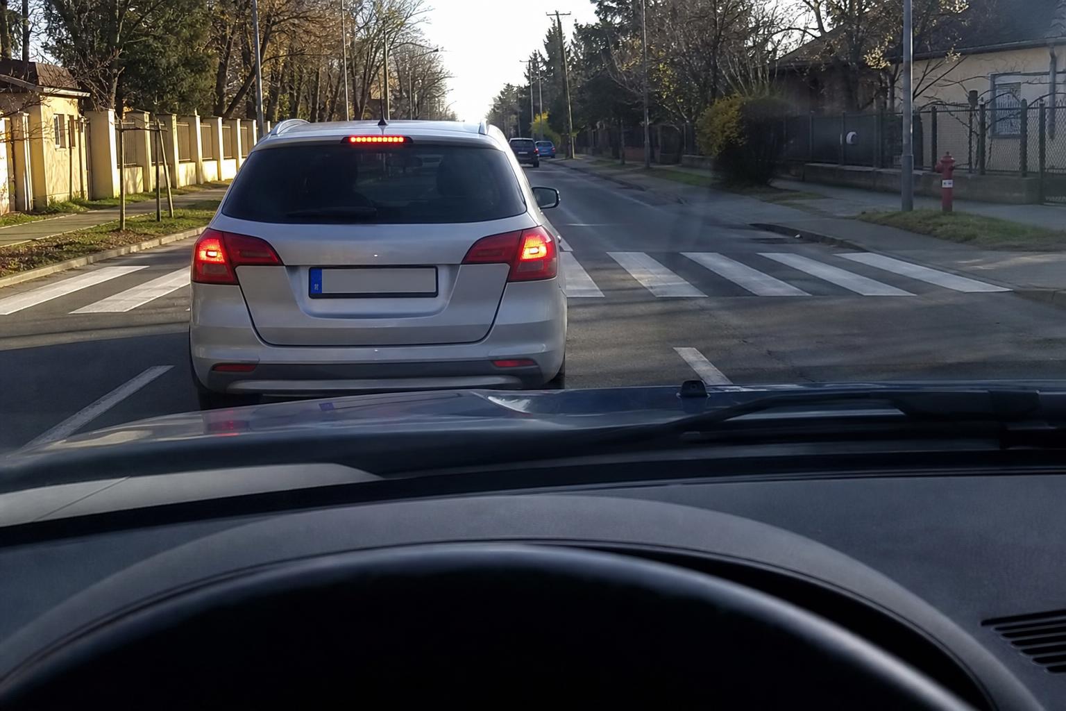 Lassító autó egy kijelölt gyalogátkelőhely előtt, amely mellett veszélyes lenne előzni