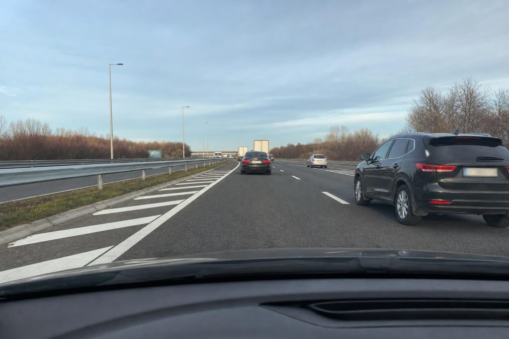 Gyorsítósáv végén a forgalmi sávba besorolni készülő autó autópályán
