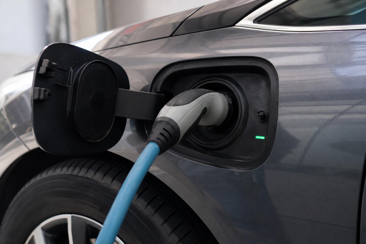 Elektromos autó csatlakoztatott AC-töltőkábellel a fedélzeti töltő ellenőrzése közben