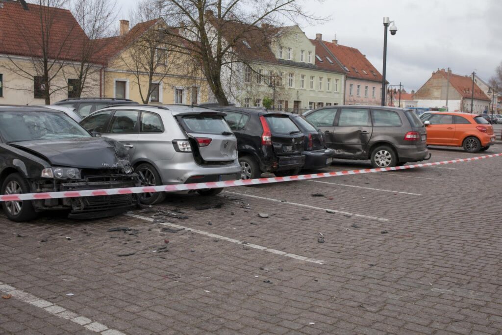 Megrongálódott autók egy lengyelországi parkolóban egy ütközéssorozat után