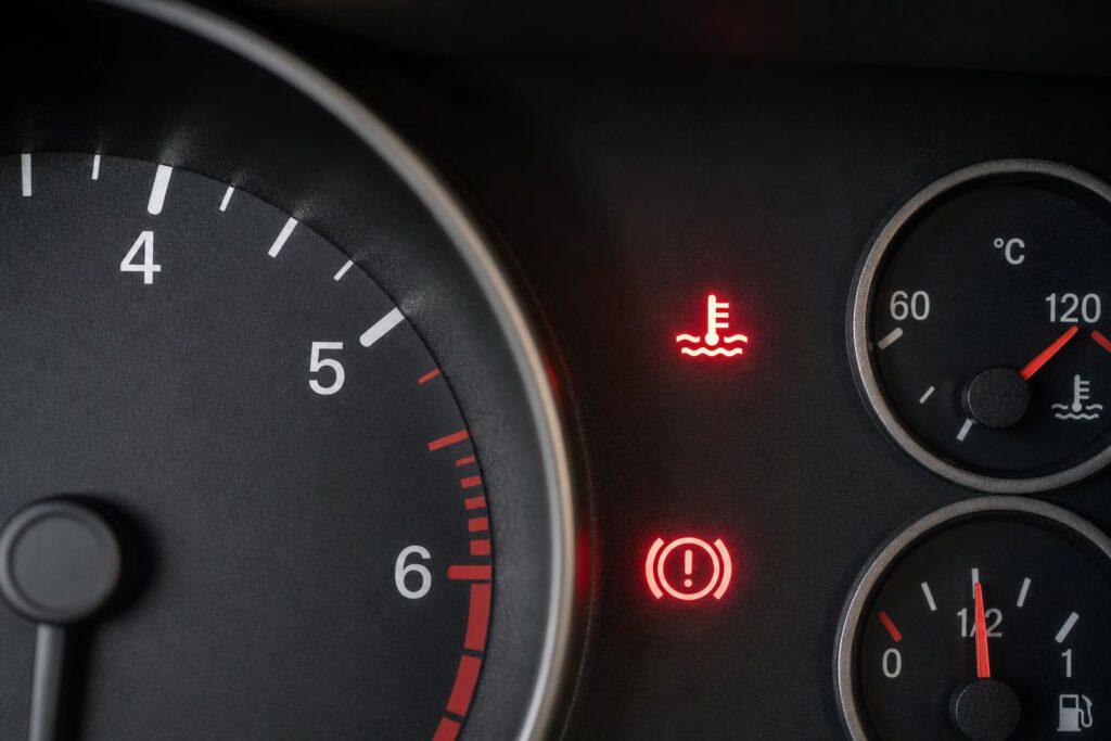 Autó műszerfala magas motorhőmérsékletet és hűtőfolyadék-hőmérséklet figyelmeztetést jelez