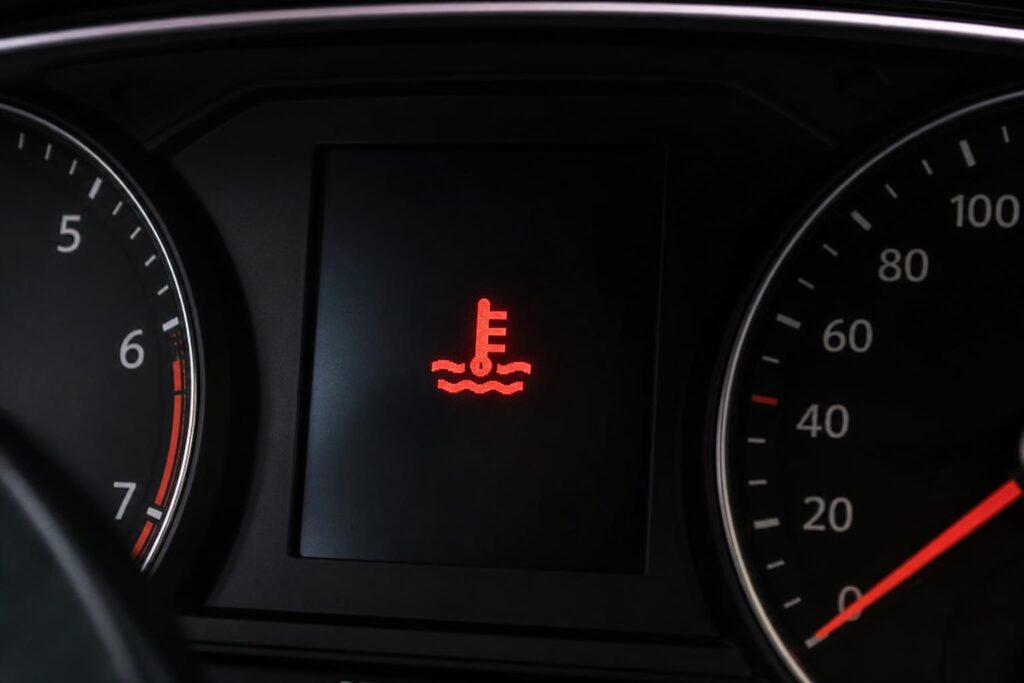 Autó motorterében látható kiegyenlítő tartály és hűtőcsövek a hűtőrendszer levegősödésének szemléltetéséhez