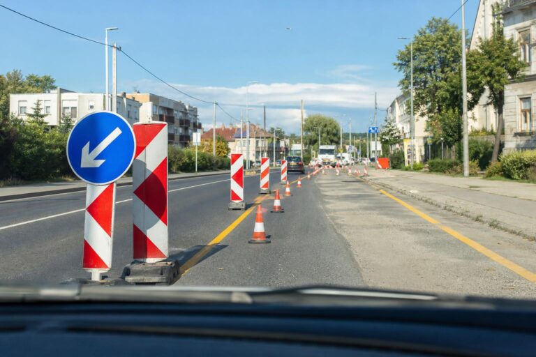 Ideiglenes forgalomterelés bójákkal, korlátokkal és útépítési jelzőtáblákkal egy magyar úton