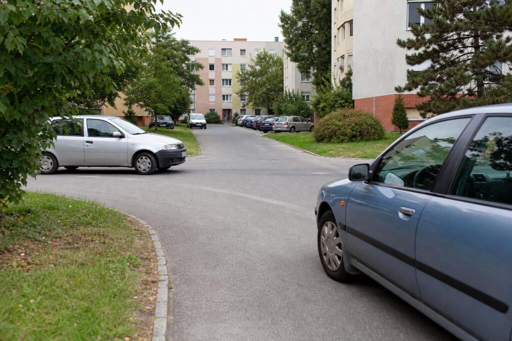 Lakótelepi belső út kereszteződése két közeledő autóval, ahol a jobbkéz-szabály alkalmazása kérdéses