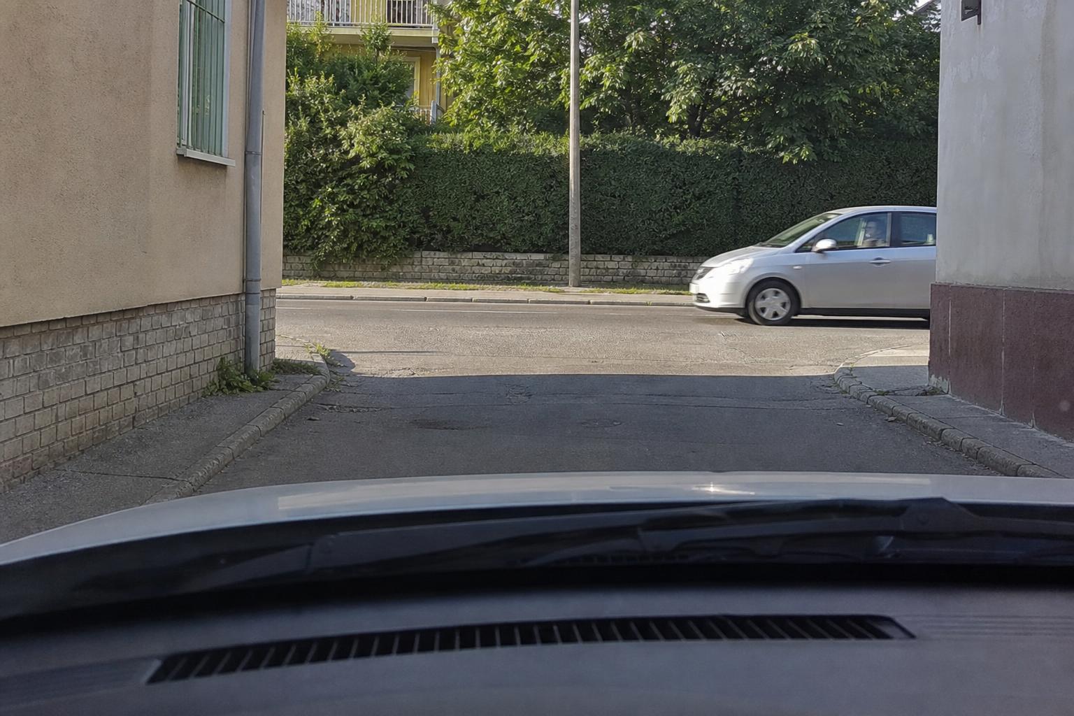 Zsákutca torkolata egy városi út kereszteződésénél, jobbról érkező autóval