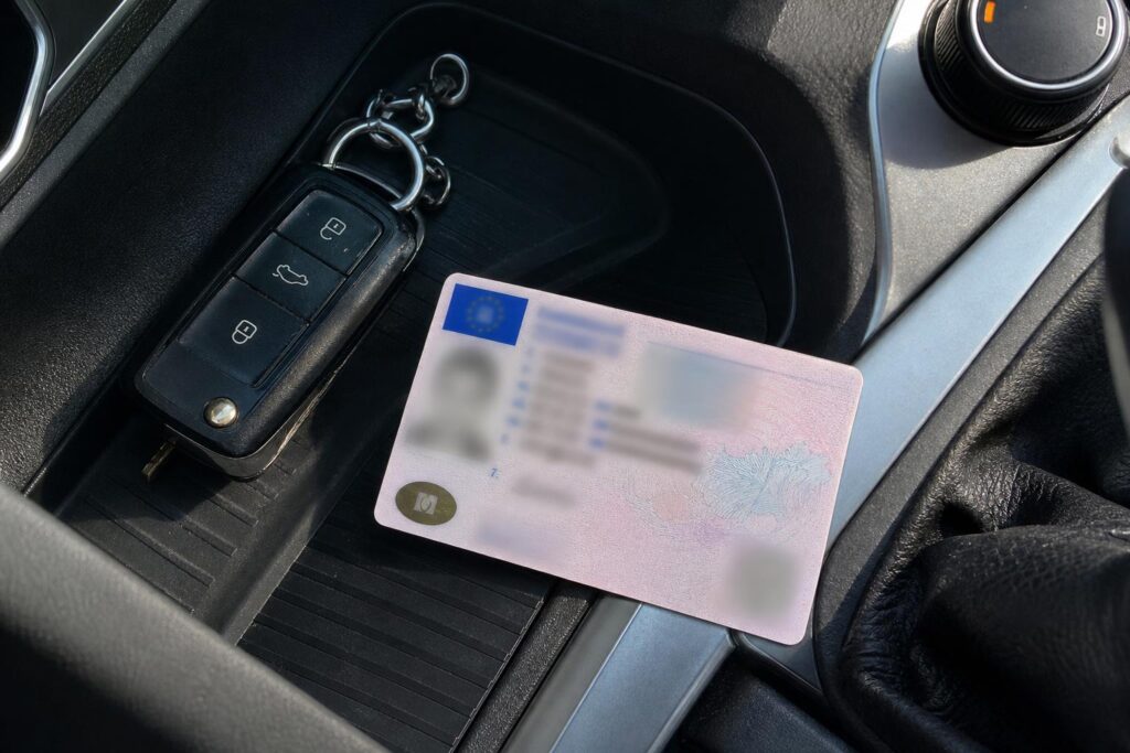 Magyar jogosítvány és autókulcs közeli, személyes adatok nélkül látható részletekkel