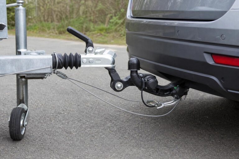 Személyautóhoz csatlakoztatott utánfutó vonóhoroggal, biztonsági kötéllel és elektromos csatlakozóval