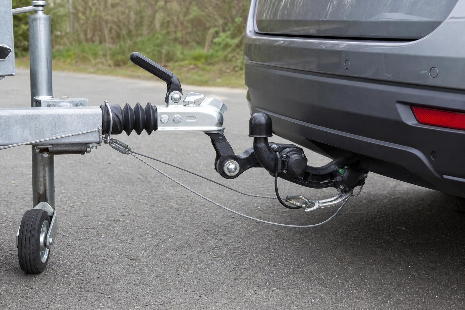 Személyautóhoz csatlakoztatott utánfutó vonóhoroggal, biztonsági kötéllel és elektromos csatlakozóval