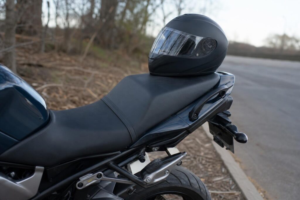Motorkerékpár hátsó utasüléssel, lábtartóval és kapaszkodószíjjal egy csendes út szélén