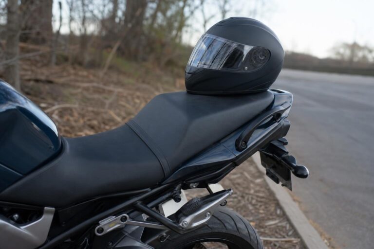 Motorkerékpár hátsó utasüléssel, lábtartóval és kapaszkodószíjjal egy csendes út szélén