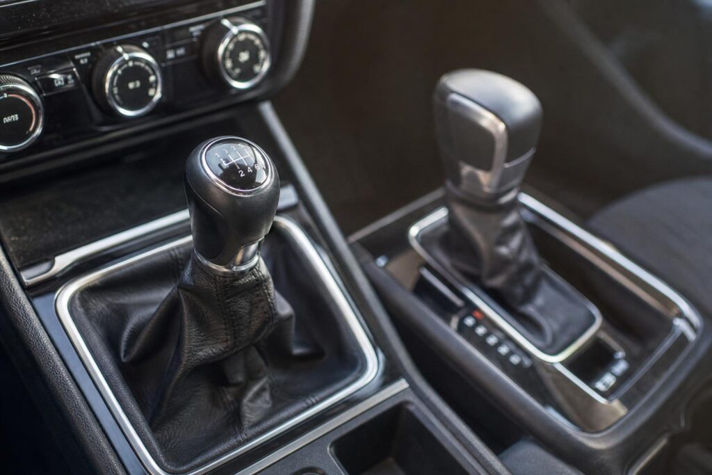 Kézi sebességváltó és automata fokozatválasztó közeli, élethű képe egy autó utasterében
