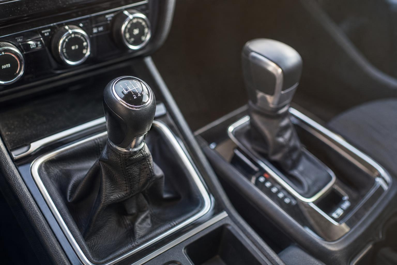 Kézi sebességváltó és automata fokozatválasztó közeli, élethű képe egy autó utasterében