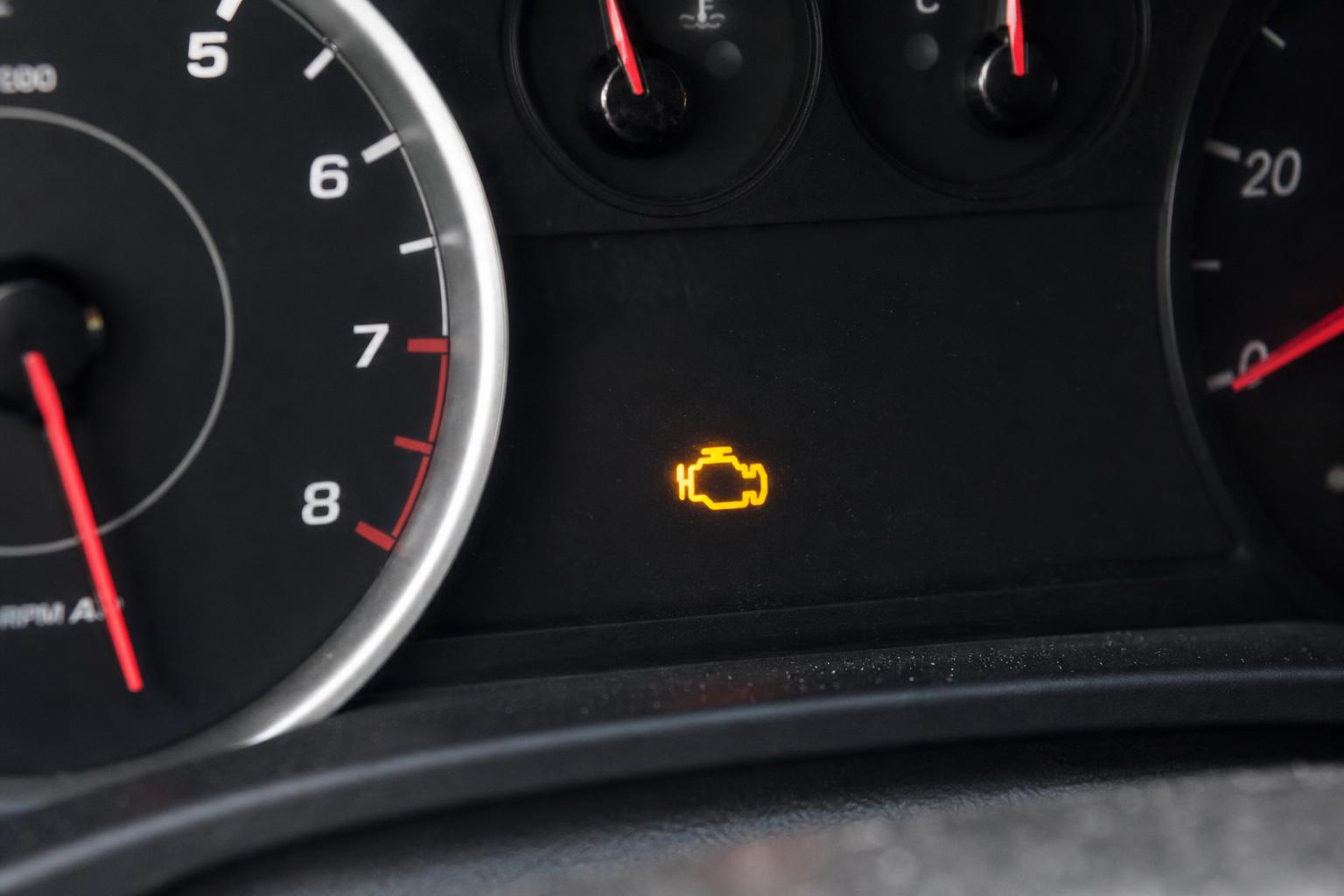 Autó műszerfala világító sárga motorhiba-jelzővel kopogásérzékelő-hiba gyanúja esetén