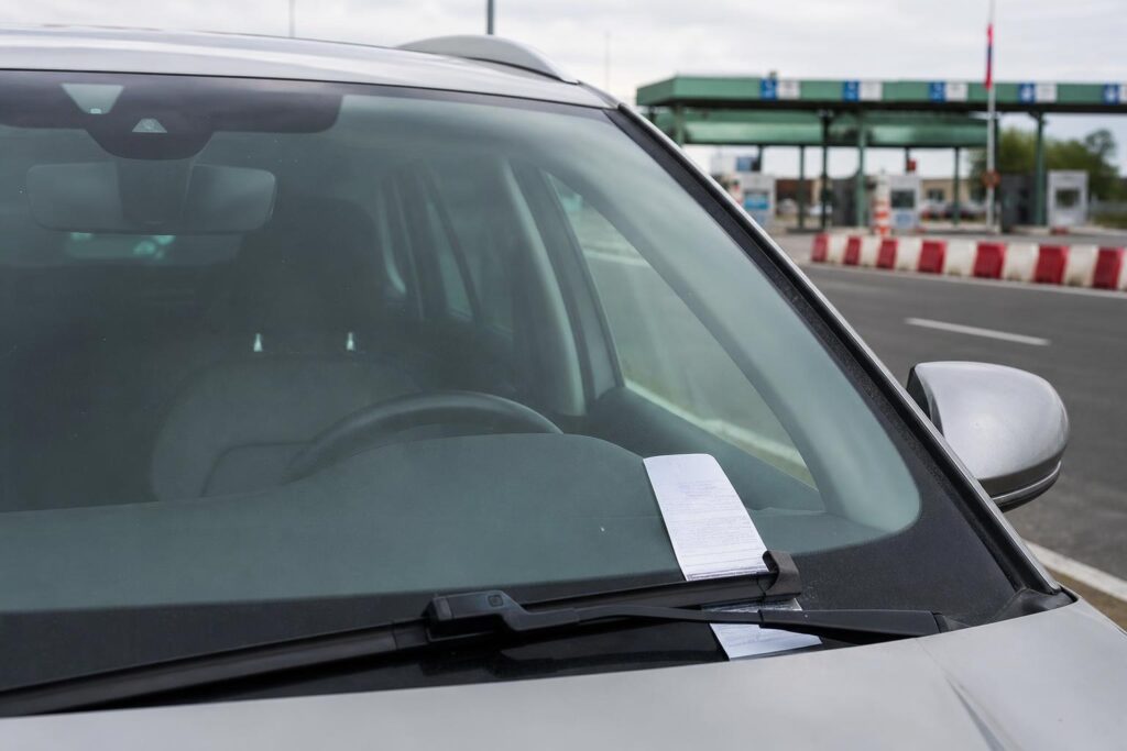 Külföldi gyorshajtási bírságot jelző értesítés egy autó szélvédőjén