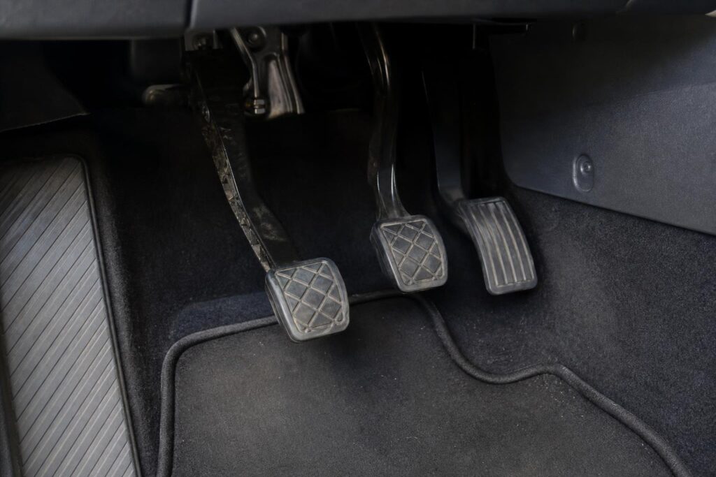 Lassan visszatérő kuplungpedál közeli, élethű képe egy kézi sebességváltós autóban