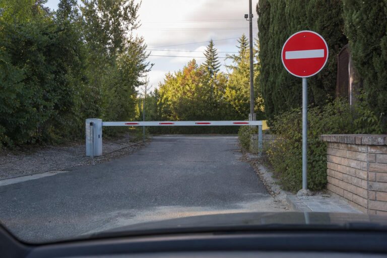 Autó sorompóval lezárt magánút bejáratánál, behajtást tiltó jelzéssel