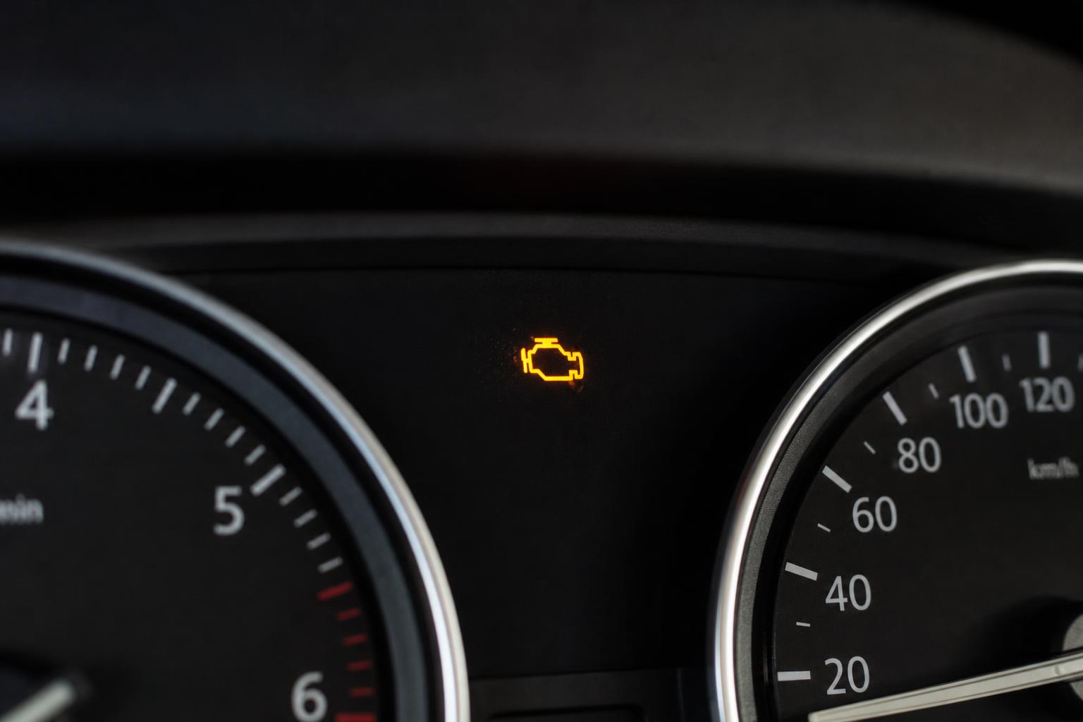 Autó műszerfala világító motorhiba-jelzővel, amikor a motor csak gázadásra marad járva
