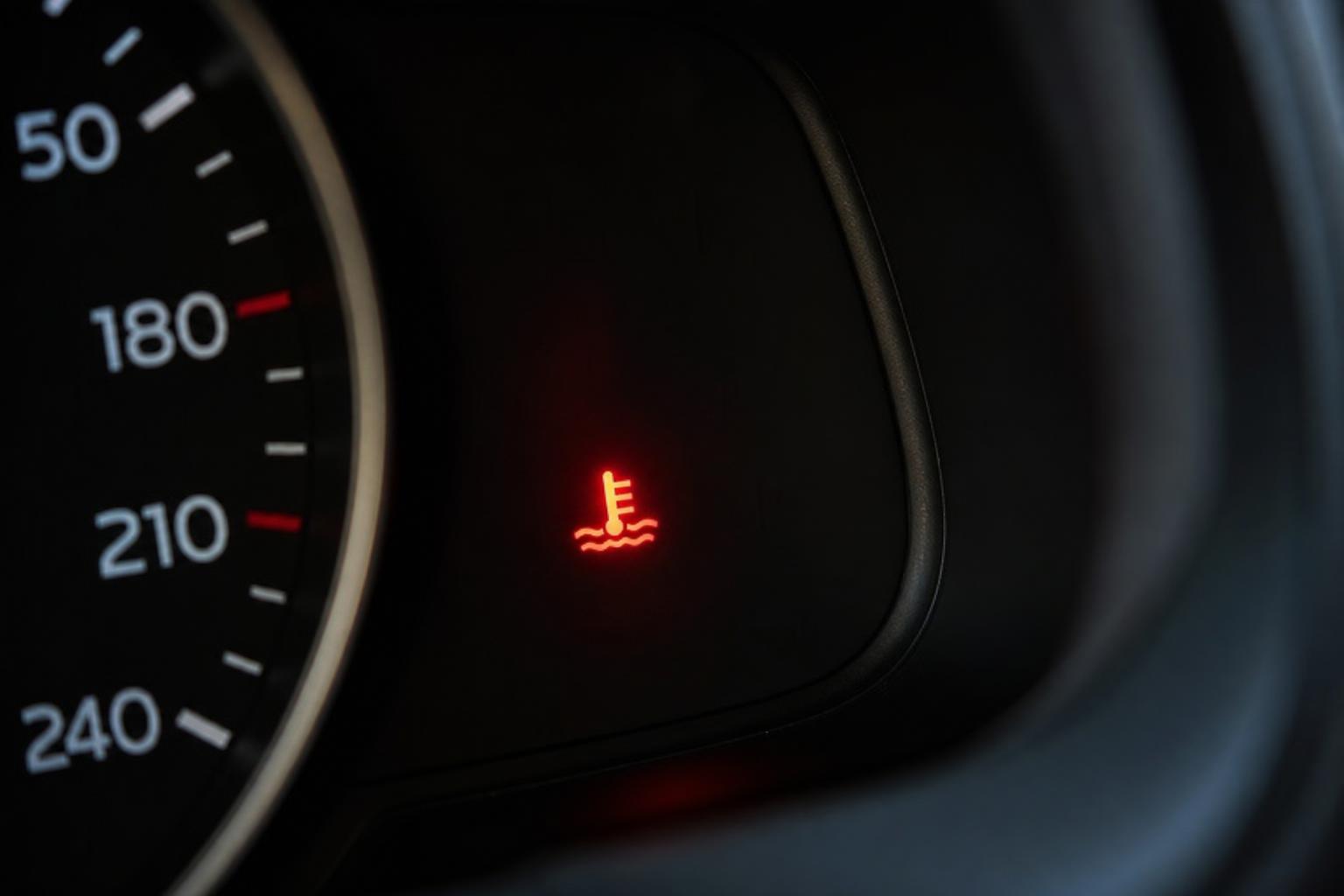 Autó műszerfala világító piros motorhőmérséklet-visszajelző ikonnal