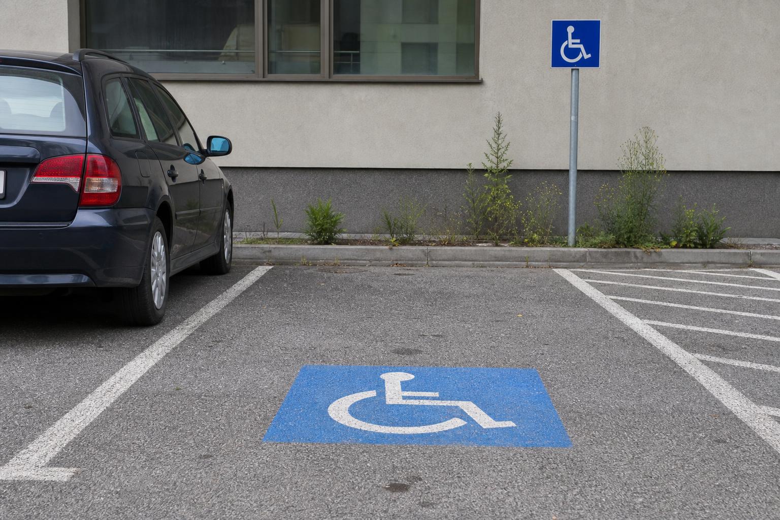 Mozgáskorlátozottak számára kijelölt parkolóhely kerekesszék-piktogrammal és parkolótáblával