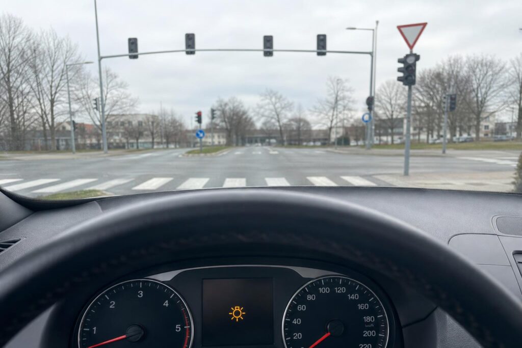 Kikapcsolt közlekedési lámpa egy városi kereszteződésben, elsőbbségi táblával és gyalogos-átkelőhellyel