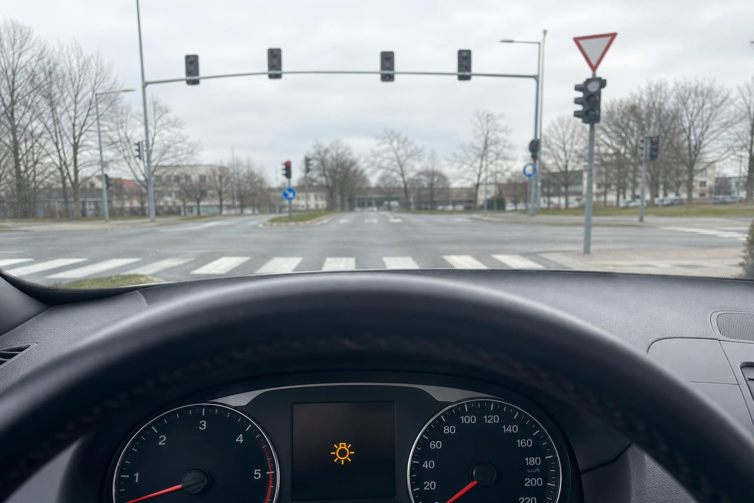 Kikapcsolt közlekedési lámpa egy városi kereszteződésben, elsőbbségi táblával és gyalogos-átkelőhellyel