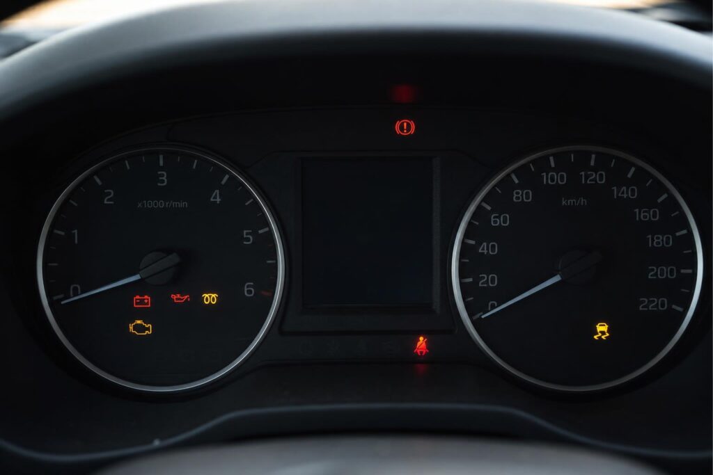 Autó műszerfala meleg motor újraindításakor, a lassan forgató önindító hibájára utaló halványuló műszervilágítással
