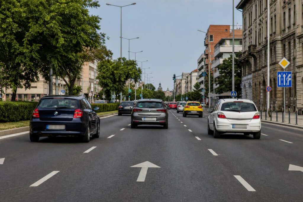Többsávos városi út párhuzamosan haladó autókkal és jól látható forgalmi sávokkal