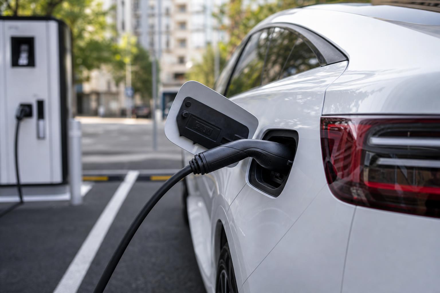 Elektromos autó csatlakoztatott töltőkábellel kijelölt töltőhelyen