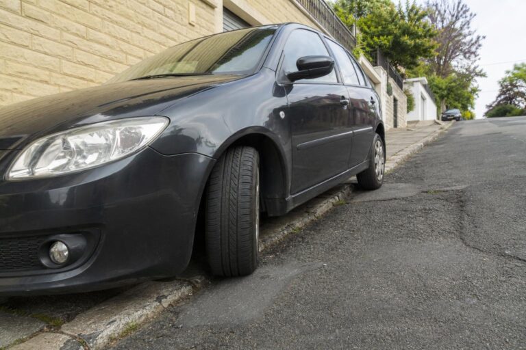 Lejtős úton biztonságosan rögzített, elfordított kerekű személyautó