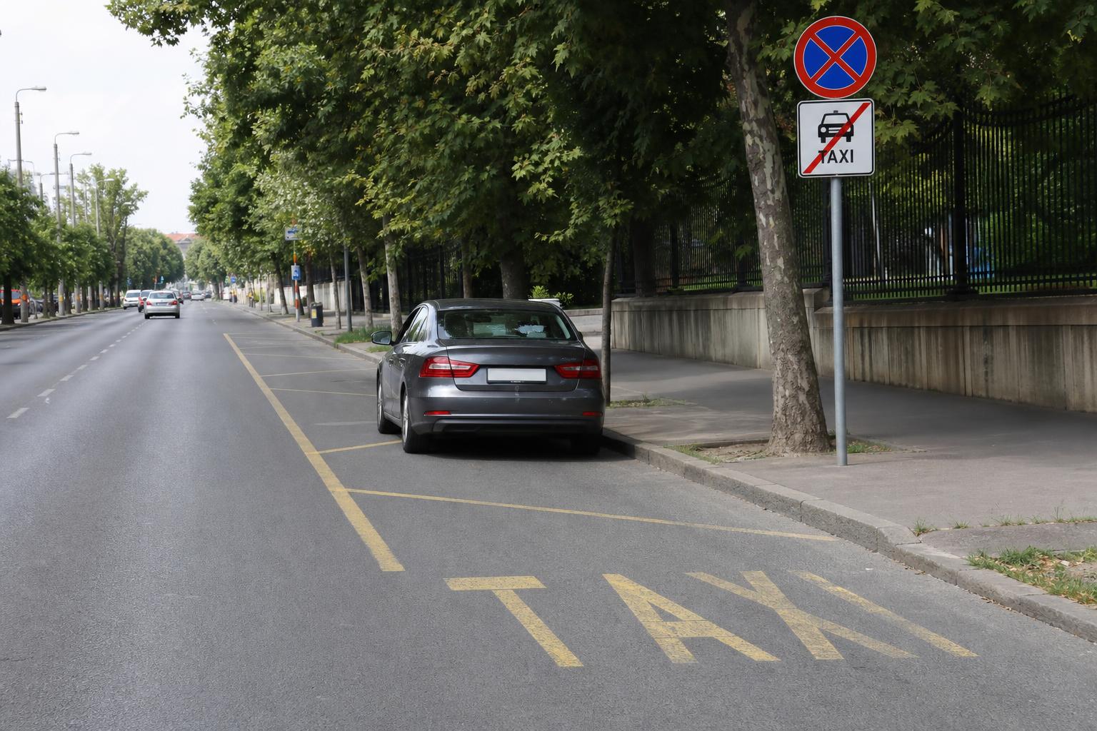 Taxiállomás végét jelző útszakasz és az utána álló személyautó közúti környezetben