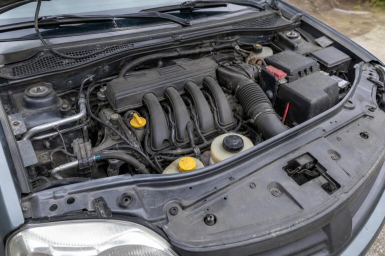 Használt autó nyitott motortere álló helyzetben végzett ellenőrzés közben