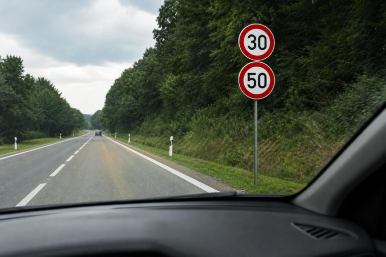 Autóból látható út, ahol a 30-as sebességkorlátozást egy 50-es sebességtábla váltja fel
