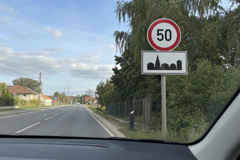 Sebességkorlátozó és lakott terület kezdetét jelző tábla együtt egy magyarországi úton