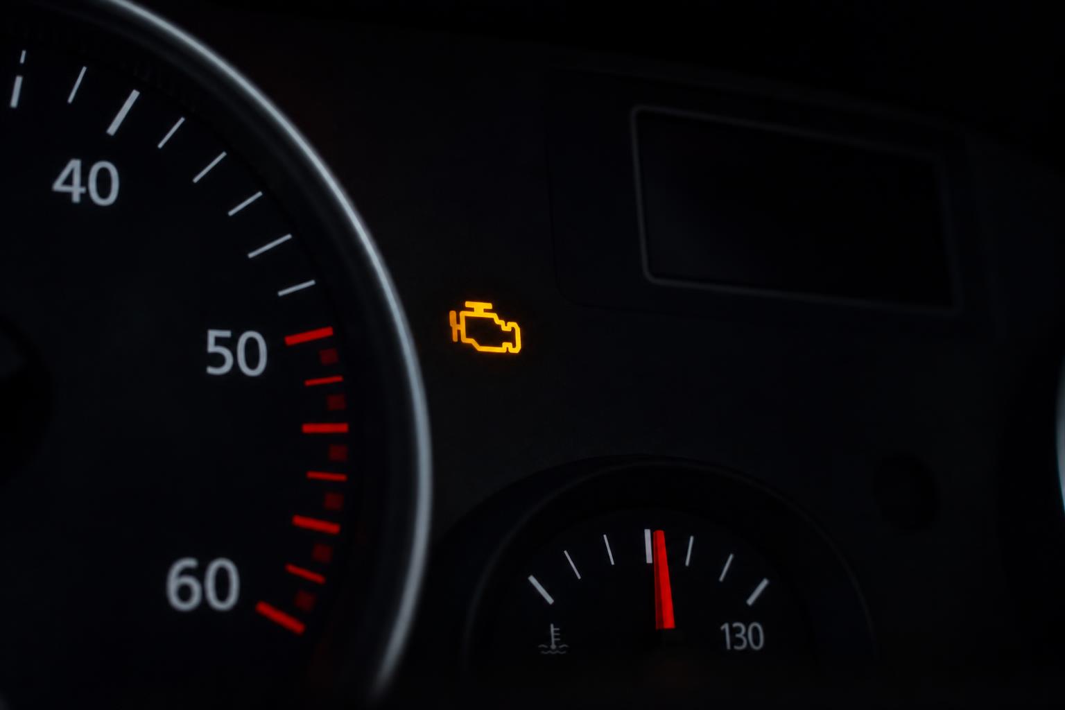 Autó műszerfala világító motorhiba-visszajelzővel, amely szívósor-kokszosodás gyanújára is utalhat