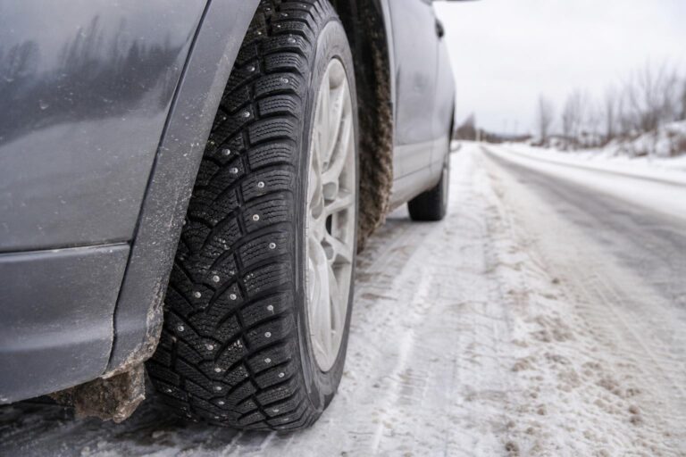 Szöges téli gumiabroncs fémszegekkel havas út mellett
