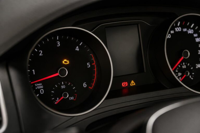 Közeli, élethű fotó egy autó műszerfaláról világító sárga check engine motorhiba-jelzővel