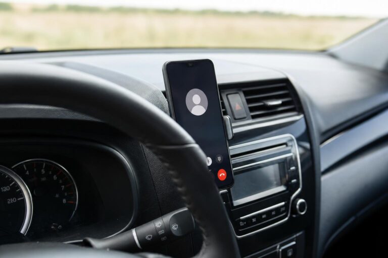 Biztonságosan rögzített telefon autóban, kihangosító rendszerhez csatlakoztatva